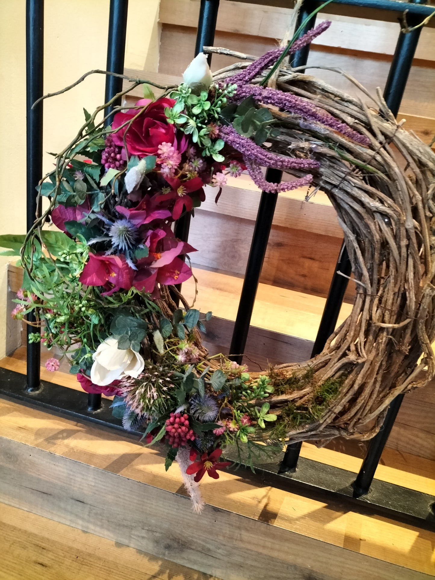 Krans afgewerkt met kunstbloemen.